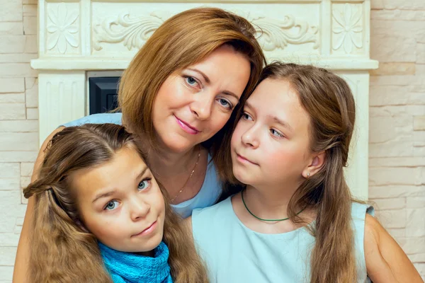 Madre y sus dos hijas sentadas cerca de la chimenea . —  Fotos de Stock