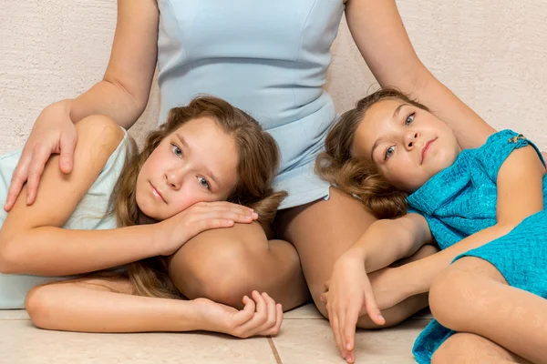 Två flickor ljuger i sin mors knä. — Stockfoto