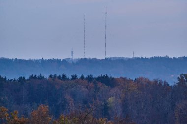 Uzakta bir tepenin üstündeki televizyon kulesi. Mavi saatte sonbahar manzarası.