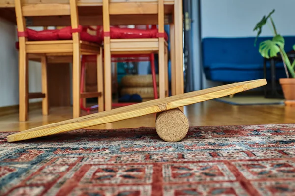 Wooden balance board in a living room. Home workout with a wooden balance board. Workout during quarantine.