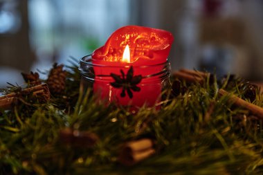 Dekoratif çelenk ve yanan Noel mumu..