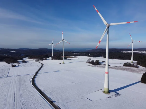 Aerial view of a wind farm in winter. Aerial view of wind turbines on a snowy field in Germany.