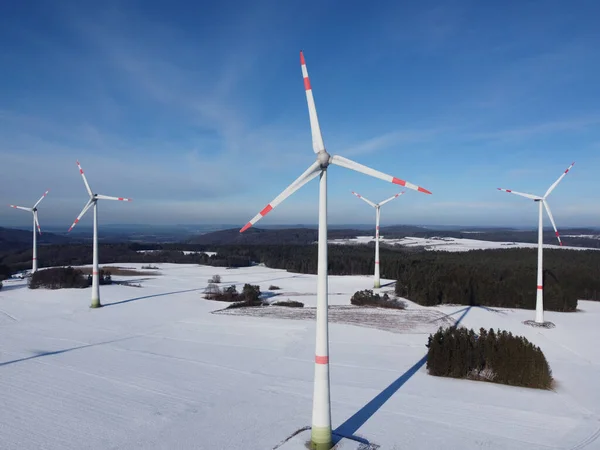 Aerial view of a wind farm in winter. Aerial view of wind turbines on a snowy field in Germany.