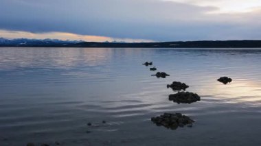 Gün batımında dağ gölü ve arka planda bir dağ sırası. Günbatımında Bavyera 'da Ammersee.