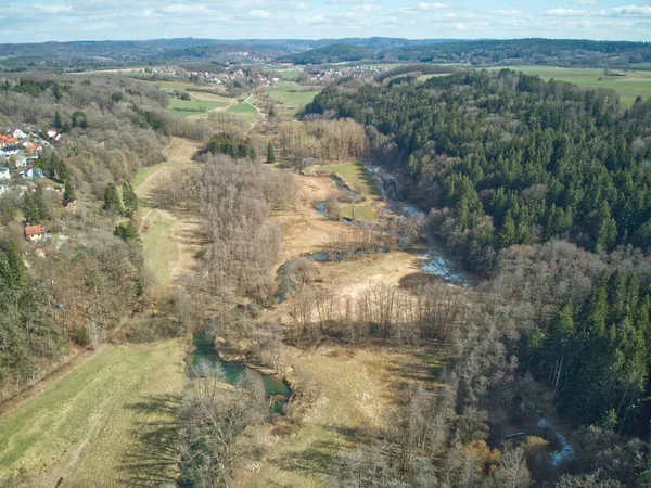 Aerial shot of a meandering river. Aerial shot of a turquoise river flowing through a conifer forest.