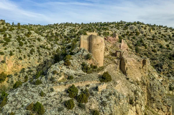 Aerial view of Santa Croche (Saint Cross) medieval castle ruin on the road to Albarracin Spain on a steep crag with a semi circular donjon and partially ruined embrasure