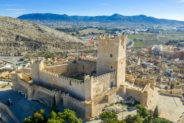 Aerial view of Atalaya castle over Villena Spain. The fortress has concentric plan, with a rectangular barbican forming space in front of the keep.  The external wall has chemin-de-ronde or wall-walk clipart