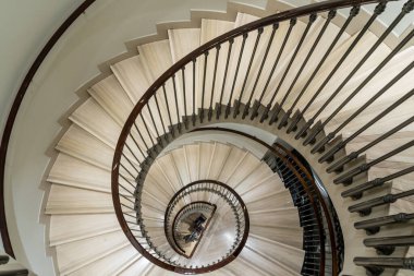 Mermer basamaklarla aşağı doğru dönen zarif spiral merdiven.