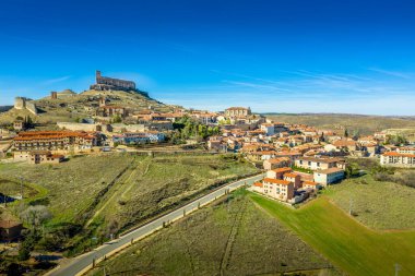 Castille ve Leon İspanya 'da şehir duvarları olan ortaçağ harap kalesi ve kasabasının mavi gökyüzü ile Atienza hava manzarası
