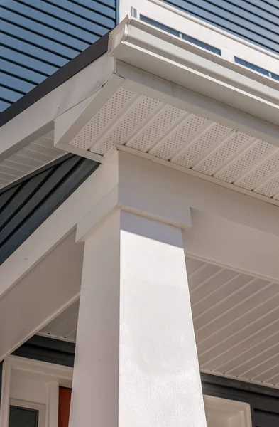 Colonial white gutter guard system,  soffit providing ventilation to the attic, with pacific blue vinyl horizontal siding at a luxury American single family home neighborhood USA
