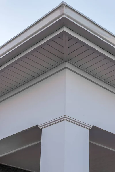 Colonial white gutter guard system,  soffit providing ventilation to the attic, with pacific blue vinyl horizontal siding at a luxury American single family home neighborhood USA