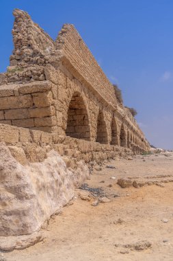 Sezar Sahili 'ndeki Roma su kemerlerinin kalıntıları. Mavi ve gökyüzü olan İsrail.