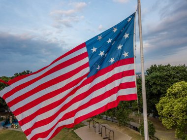 Baltimore Federal Tepesi 'nde mavi arka planda 13 yıldızlı Amerikan Bayrağı sallıyor.
