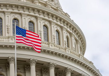 United States Capitol building with waving American flag in Washington DC clipart