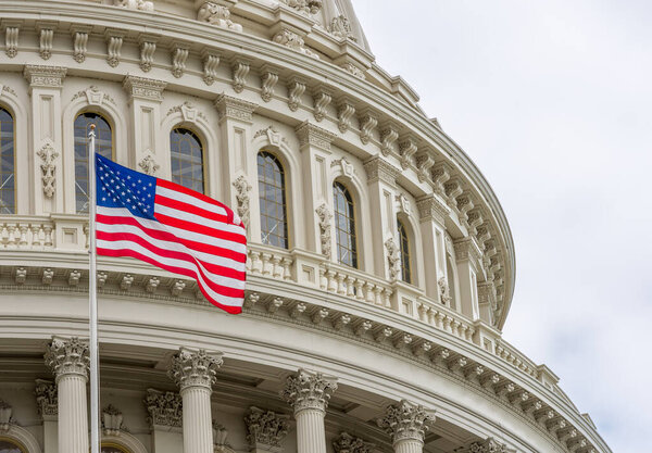 United States Capitol building with waving American flag in Washington DC