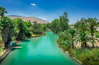 Turquoise Amal river running through the traditionally agriculture based collective community Kibbutz Nir David in Israel  clipart