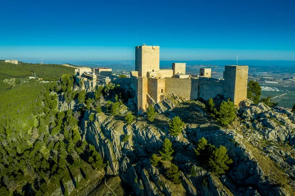Jaen Ortaçağ Gotik şatosunun üzerinde bulutlu bir gökyüzü ve dünyanın en büyük zeytinliğinin üzerinde yükselen dik bir tepenin üzerinde parador.