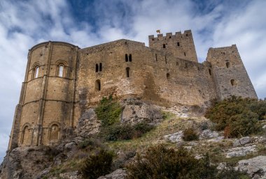 İspanya 'nın Aragon bölgesindeki Huesca yakınlarında, yüksek bir kayanın tepesinde yuvarlak kuleleri, donjon ile kısmen restore edilmiş Romen Loarre kalesinin kış manzarası