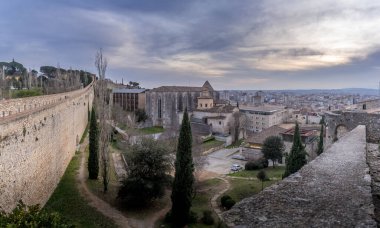 Gotik Aziz Mary Katolik katedrali, şehir duvarları ve Girona Katalonisi 'nde günbatımında renkli evler olan ortaçağ Girona manzarası