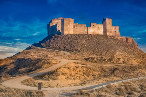 Aerial view of the ruined medieval abandoned Montearagon castle, namesake of the famous kingdom on a bare mountain top near Huesca, Aragon province Spain with blue sky