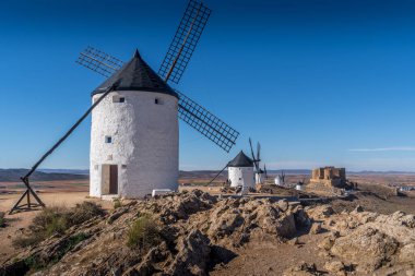 La Mancha İspanya 'nın ünlü Don Kişot sahasında mavi gökyüzü olan Consuegra kalesi ve yel değirmenleri manzarası