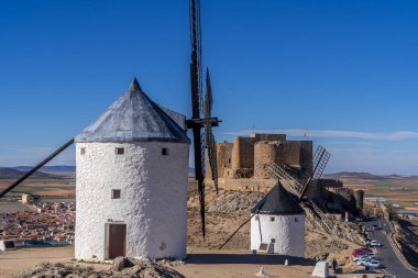 La Mancha İspanya 'nın ünlü Don Kişot sahasında mavi gökyüzü olan Consuegra kalesi ve yel değirmenleri manzarası