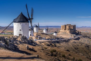 La Mancha İspanya 'nın ünlü Don Kişot sahasında mavi gökyüzü olan Consuegra kalesi ve yel değirmenleri manzarası