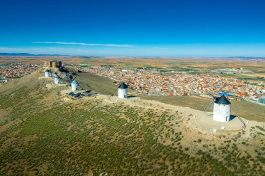 La Mancha İspanya 'nın ünlü Don Kişot sahasında mavi gökyüzü olan Consuegra kalesi ve yel değirmenleri manzarası