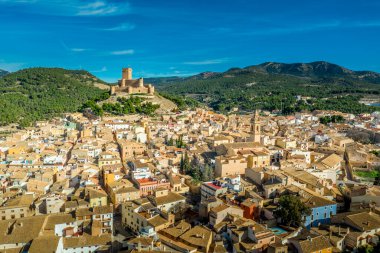 İspanya 'nın Valensiya eyaletindeki Biar Kalesi' nin havadan görünüşü. Donjon şehrin üzerinde yükseliyor ve mavi gökyüzü olan güneşli bir günde yarı dairesel kulelerle güçlendirilmiş eşmerkezli duvarlar.