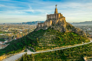 Monteagudo Ortaçağ Şatosu tepeyi çevreleyen on iki dikdörtgen kuleyi ve Murcia İspanya yakınlarındaki İsa Mesih heykelinin kutsal kalbini harabeye çevirdi.