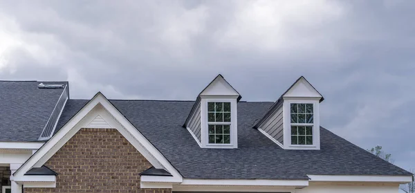 American neighborhood street with typical east coast brick triangle facade townhouses, white attic vent, dormer windows on roof