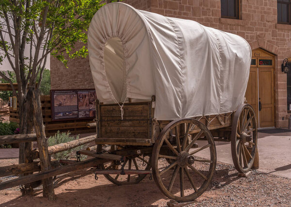 Traditional horse drawn wagon with white canvas cover used by pioneers to travel in the American Wild West