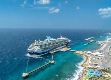 Karayip adası Curacao Willemstad 'a yanaşan lüks yolcu gemisinin hava manzarası turkuaz suyla çevrili.