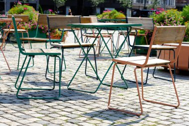 Bir şehir caddesinde bar masaları ve sandalyeler