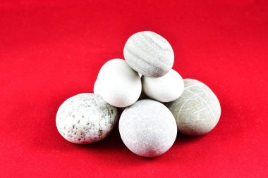 Küçük deniz taşları bir araya toplanmış, kompozisyon, dekorasyon, kırmızı zemin