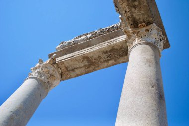Bir zamanlar Türkiye 'nin Antalya kenti yakınlarındaki Pamphylia Secunda' nın başkenti olan Perge 'de mavi gökyüzüne karşı korint tarzı mermer sütunlar.