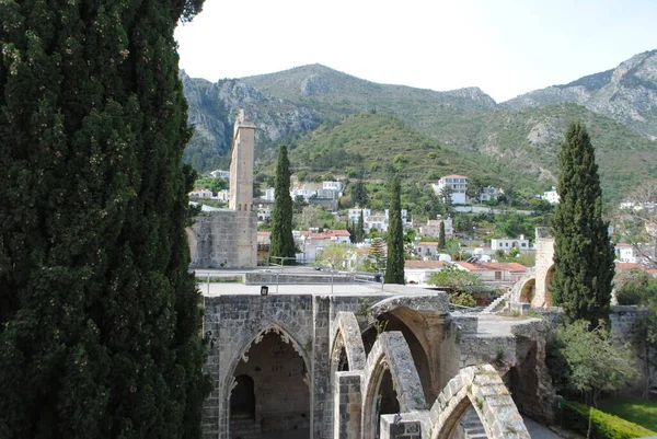 Abbazia di Bellapais con il villaggio di Bellapais e le montagne, risalente al XIII secolo. Kyrenia, Girne Cipro del Nord Foto Stock Royalty Free