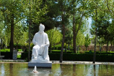 Mashhad İran. Nisan 2019. 10. yüzyıl İranlı şair Ferdowsi 'nin heykeli. Etrafı uzun ağaçlar ve su akıntılarıyla çevrili. Mashhad İran