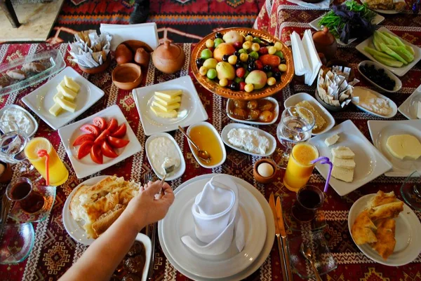 Turkic breakfast with variety of fresh fruits, cheese, yogurt, honey, marmalade, juice, pastry and tea on a restaurant table in Gebele Azerbaijan.