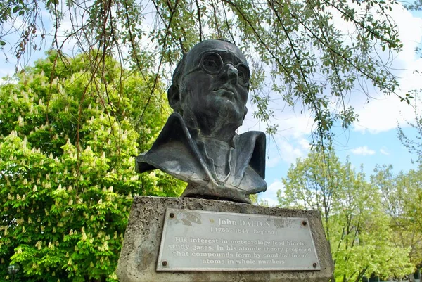 John Dalton 'un büstü mavi gökyüzüne karşı METU yeşillik parkında İngilizce plakalı. Dalton, en çok atom teorisini kimyaya dahil etmesiyle tanınan bir İngiliz bilim adamıdır.. 