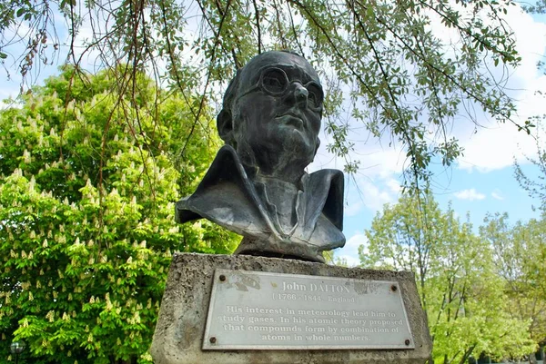 Il Busto di John Dalton contro il cielo blu con targa inglese al parco verde METU. Dalton è uno scienziato inglese, meglio conosciuto per aver introdotto la teoria atomica nella chimica. Immagini Stock Royalty Free
