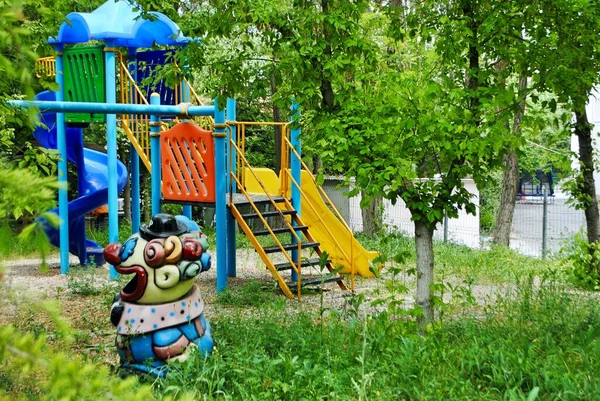 Empty colorful playground park with big trees and thick weeds due to coronavirus, Covid-19. Cayyolu Ankara Turkey.