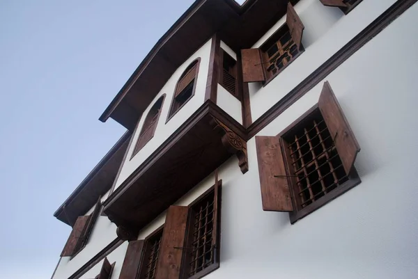 Traditional ottoman house opened windows against blue sky in Safranbolu, Turkey. UNESCO world heritage site. Low angle. Copy space. — Stock Photo, Image