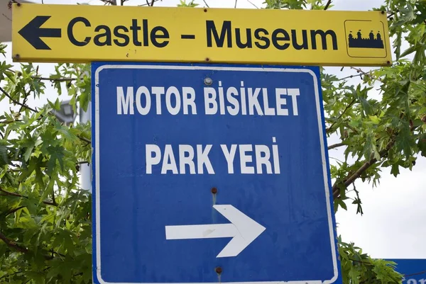 Şato ve müzenin işareti ve Motosiklet Otoparkı 'nın mavi beyaz işaretinin çevirisi. Marmaris Türkiye.