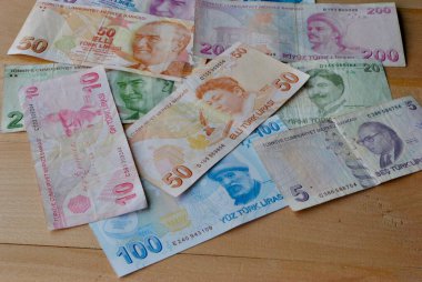 Türk Lirası 'ndan oluşan bir grup, ahşap arka plandaki faturaları ödüyor. Enflasyon kavramı, mali kriz.