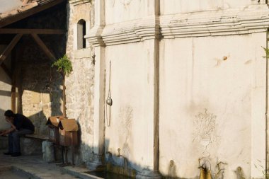 Safranbolu 'da duvarına bakır tas ve oyulmuş çiçek kazınmış eski sokak çeşmesi. UNESCO sitesi. Türkiye.
