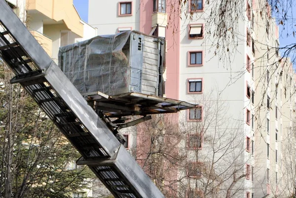 Rimozione casa con camion scala idraulica. Spostamento ascensore portando mobili in una zona residenziale. Focus selettivo. Foto Stock