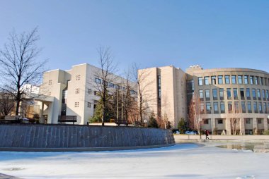 Karla kaplı beyaz kampüste buzda yürüyen erkek öğrenci. Bilkent Ankara Türkiye