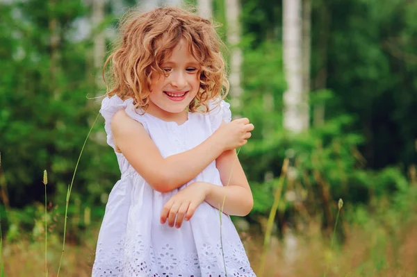 Barn Tjej leker med lämnar i sommar skog. Natur utforskning med barn. Landsbygdens utomhusaktiviteter. — Stockfoto