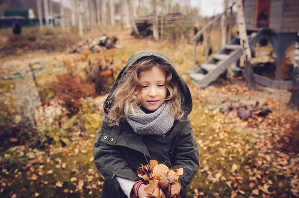 Niño feliz jugando con hojas en otoño — Foto de Stock